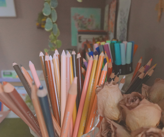 artist studio filled with pencils markers and other art supplies on an art table